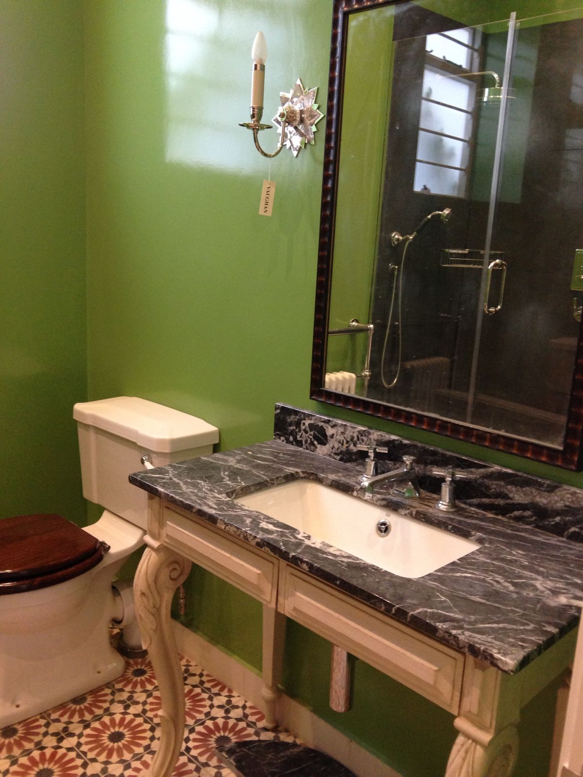 Green bathroom with marble-topped washstand and patterned floor tiles