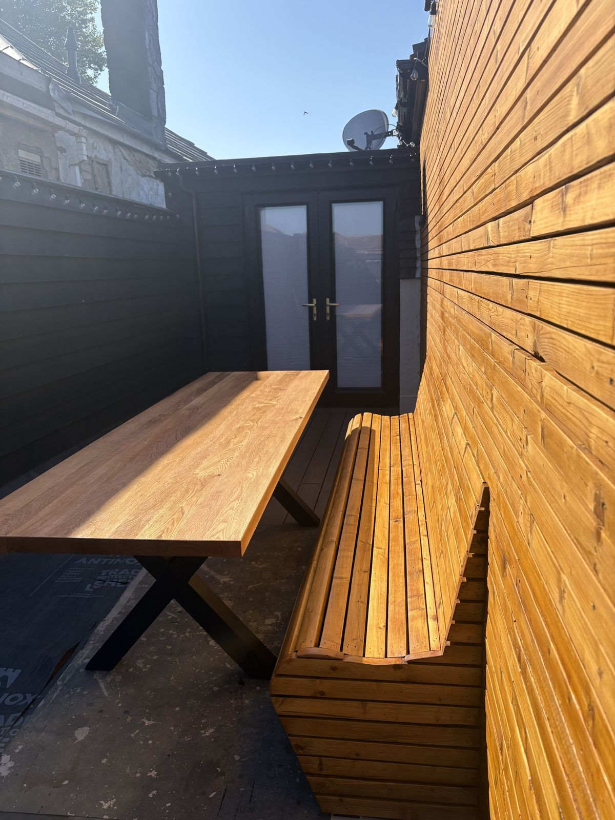 Built-in timber bench and oak table on a roof terrace