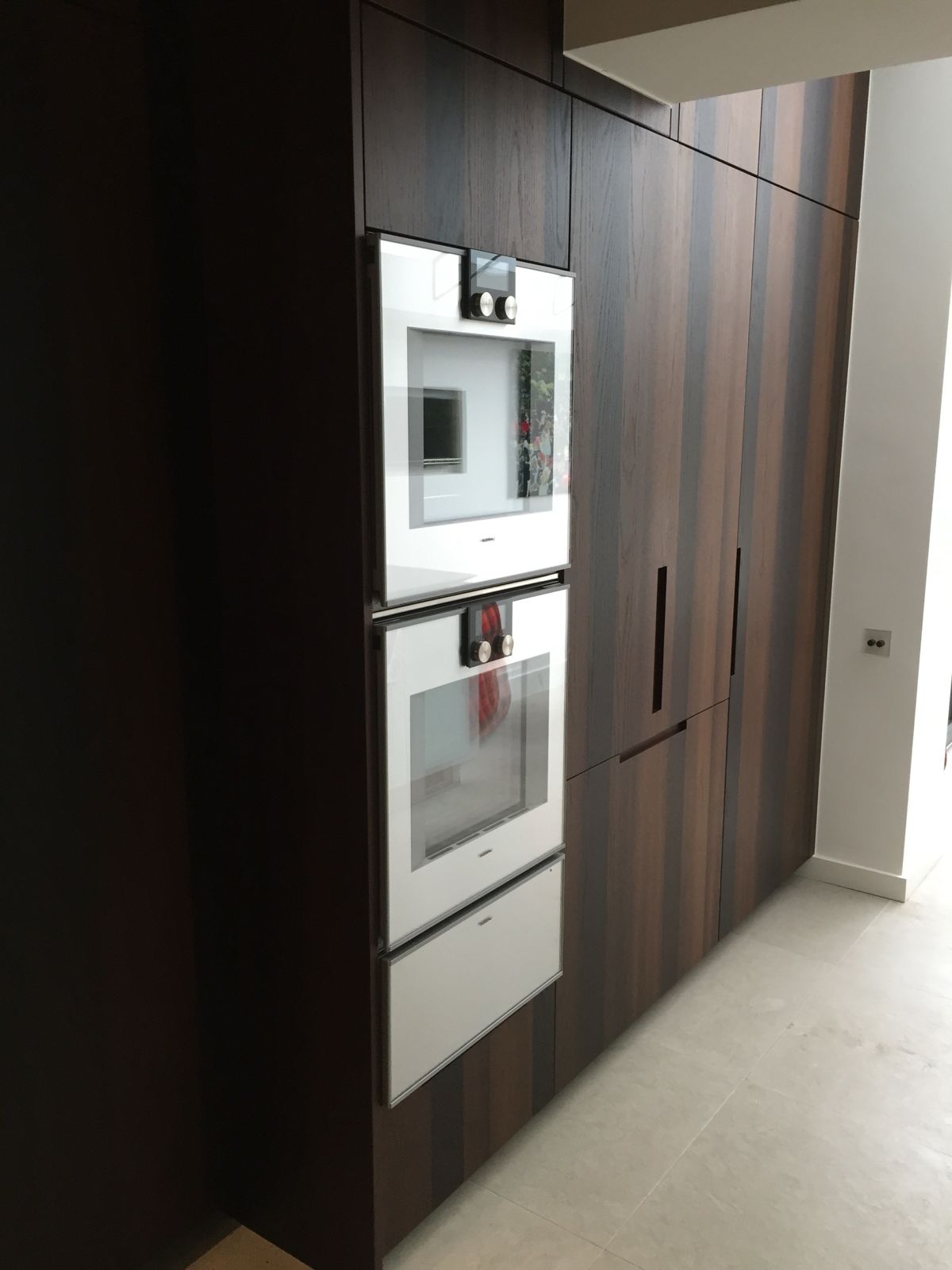 Dark oak kitchen tall units with built-in ovens